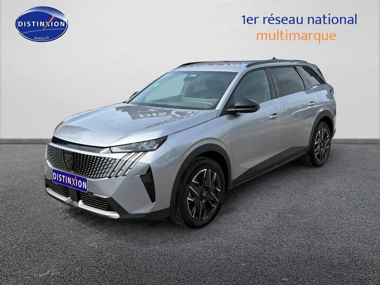 Peugeot 5008 Hybrid 145 gris Artense en 3/4 avant droit, avec calandre distinctive et jantes alu noires.