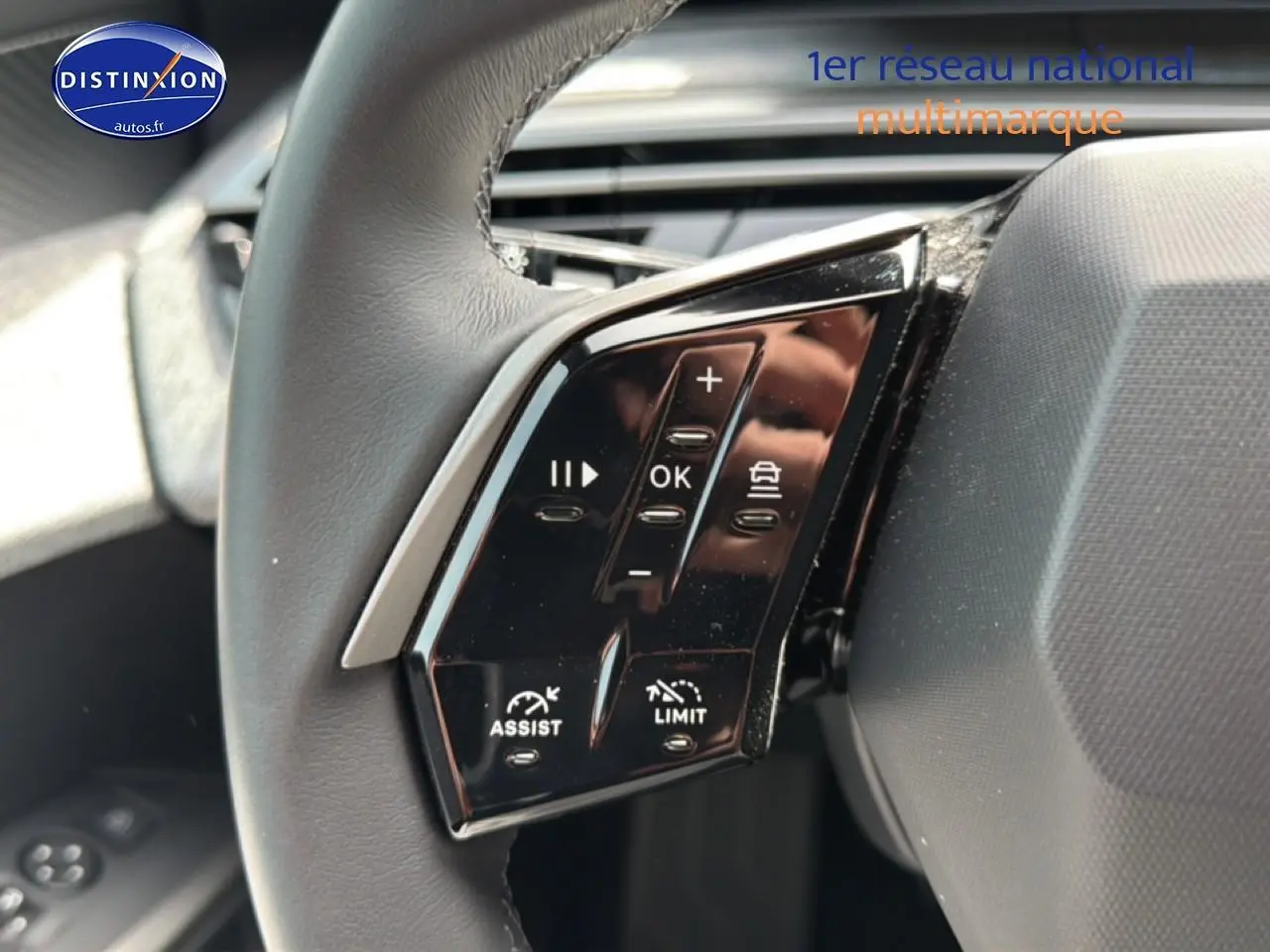 Gros plan sur les commandes multifonctions au volant cuir du Peugeot 5008 Hybrid 145 allure gris Artense.