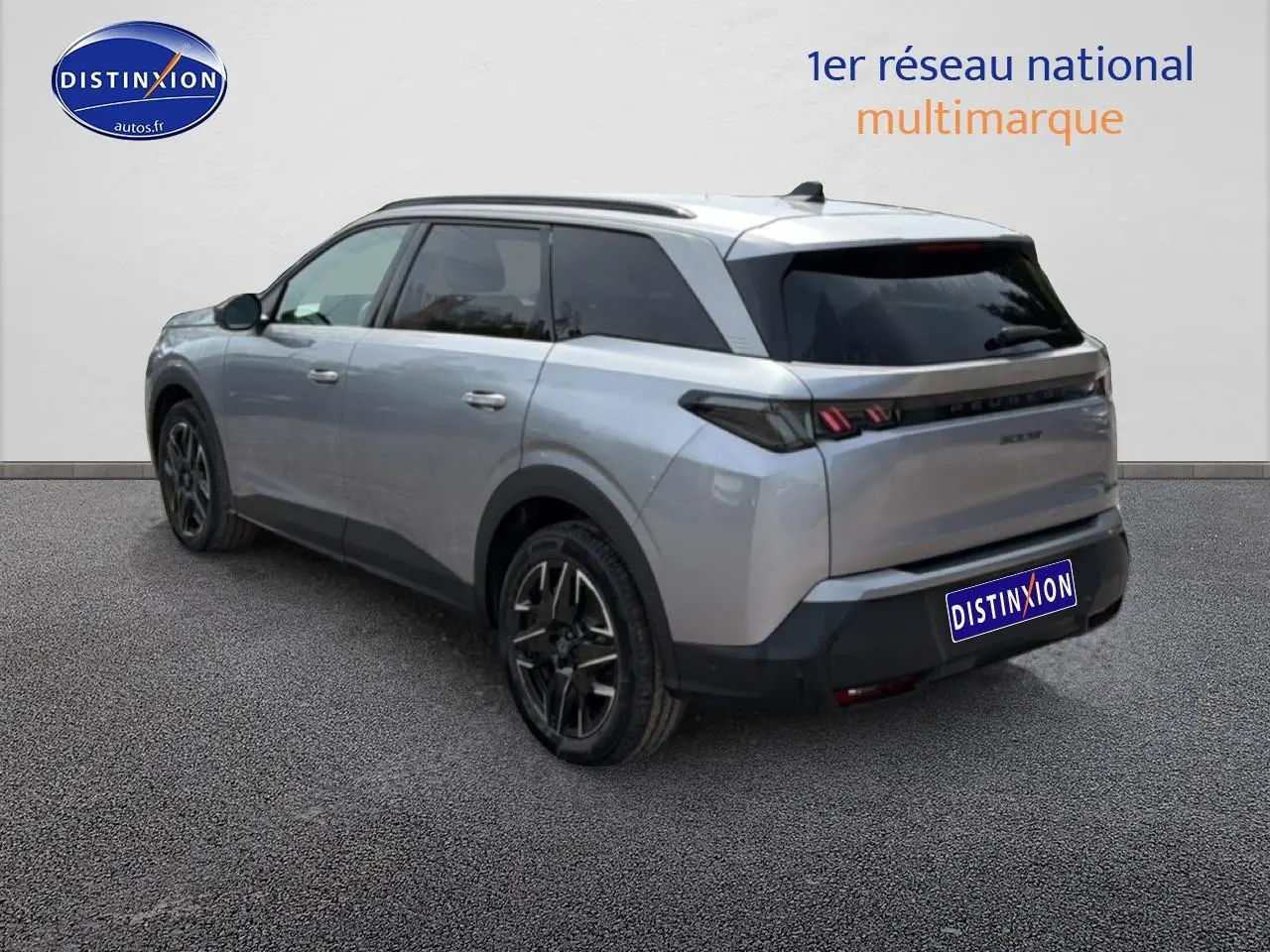 Vue 3/4 arrière droite d’un Peugeot 5008 Hybrid 145 gris artense avec vitres arrière surteintées et jantes alu noires.