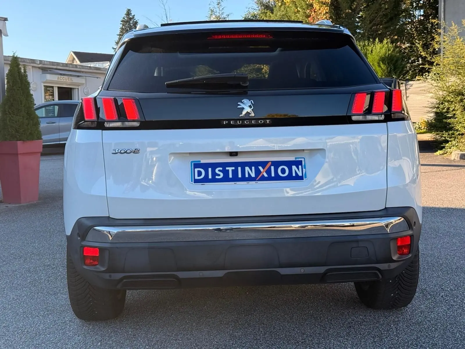 Peugeot 3008 blanc nacré vu en 3/4 arrière droit, avec feux arrière à griffes rouges et toit noir contrasté.