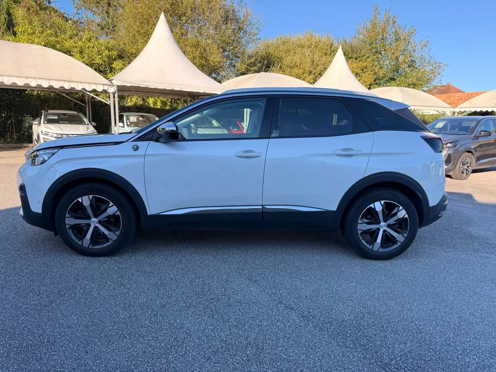 Peugeot 3008 blanc nacré vue de profil côté gauche, avec toit noir contrastant et jantes alliage bicolores.