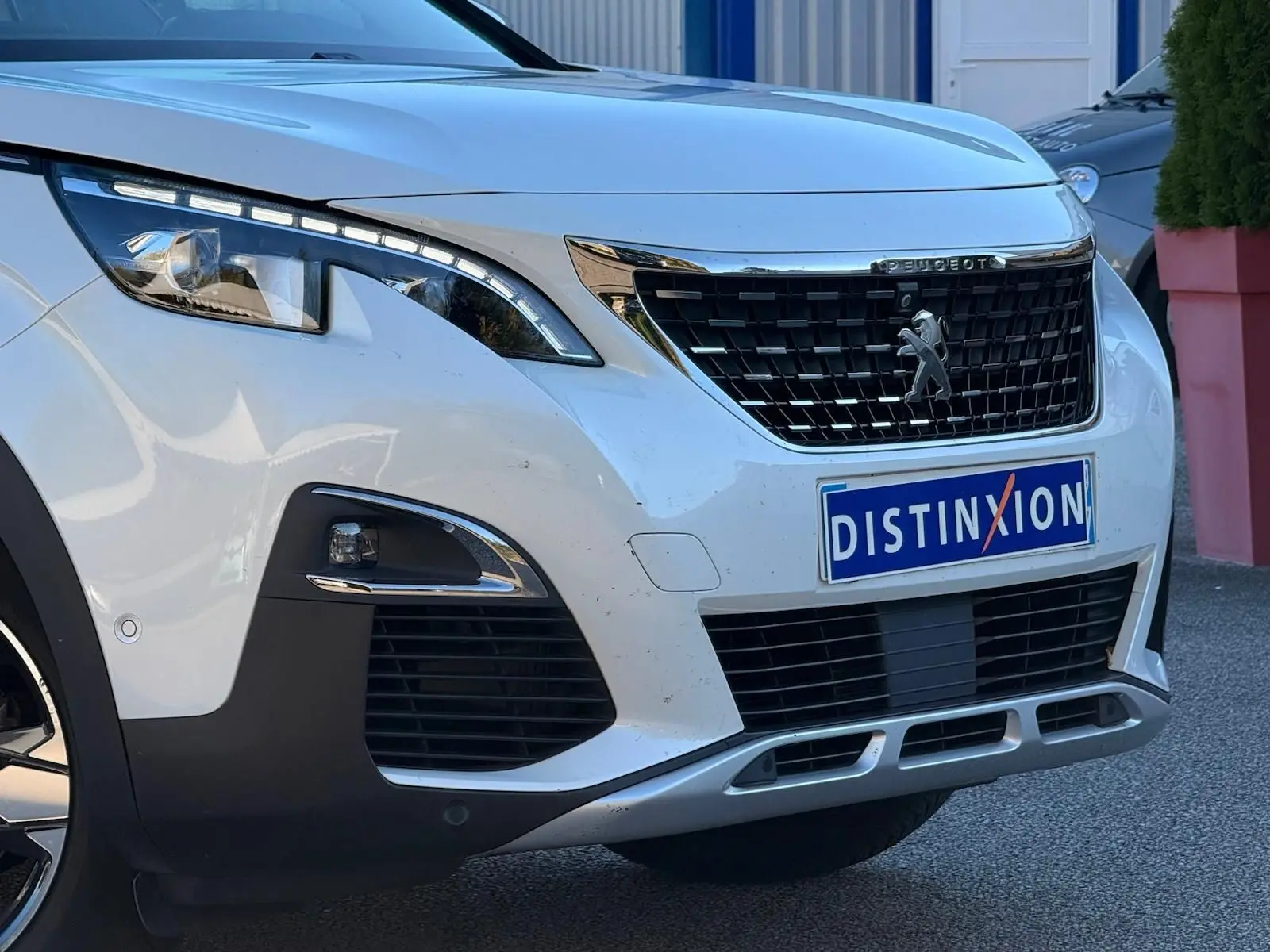Vue arrière intérieure du Peugeot 3008 blanc nacré, montrant la banquette arrière en cuir et alcantara avec appuie-têtes intégrés.