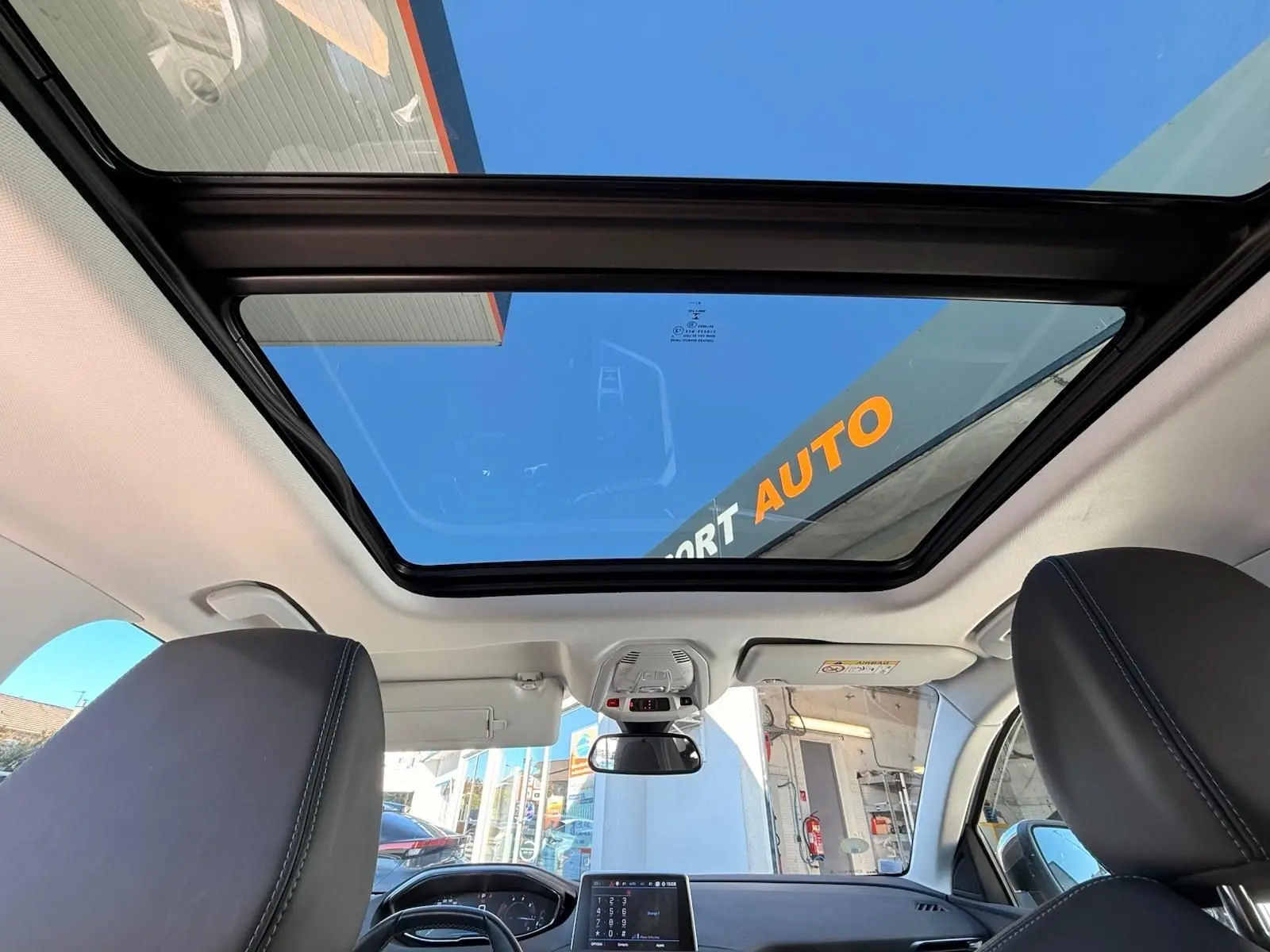 Gros plan sur les boutons d'ouverture et de verrouillage électrique du hayon du Peugeot 3008 blanc nacré, vue intérieure arrière.