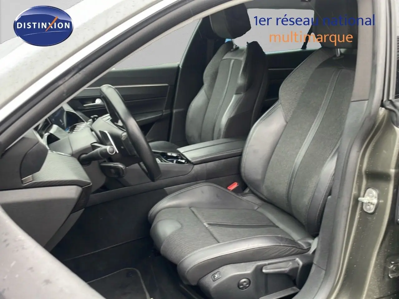 Vue intérieure côté conducteur de la Peugeot 508 SW gris amazonite, sièges mixtes cuir et tissu, volant multifonction.