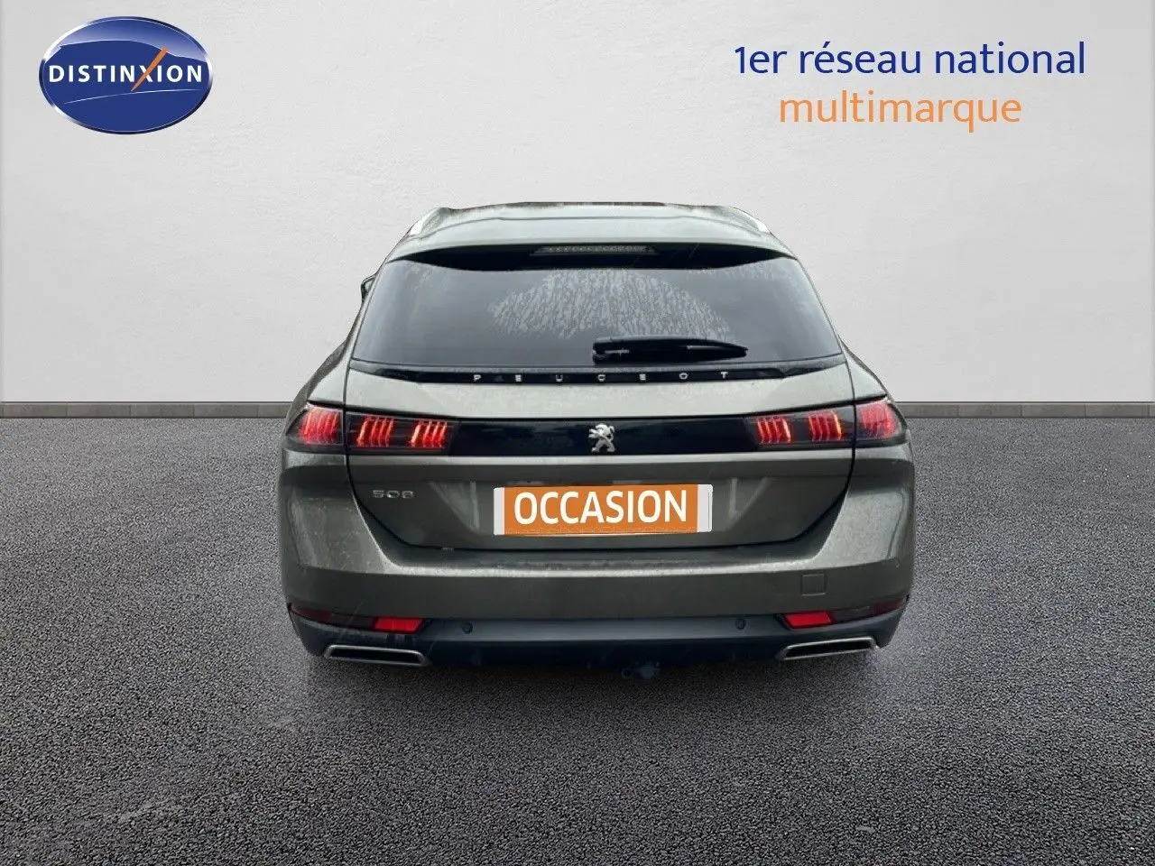 Vue arrière d'une Peugeot 508 SW gris amazonite métal avec feux LED allumés sur un sol bitumé.