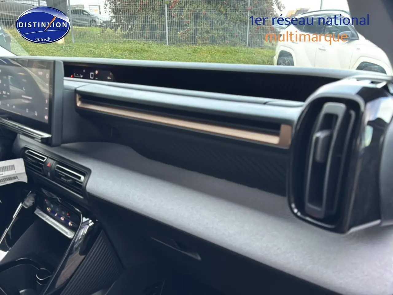 Vue intérieure côté passager du tableau de bord noir du Citroën C3 Aircross 2025 avec écran tactile et aérateurs verticaux.