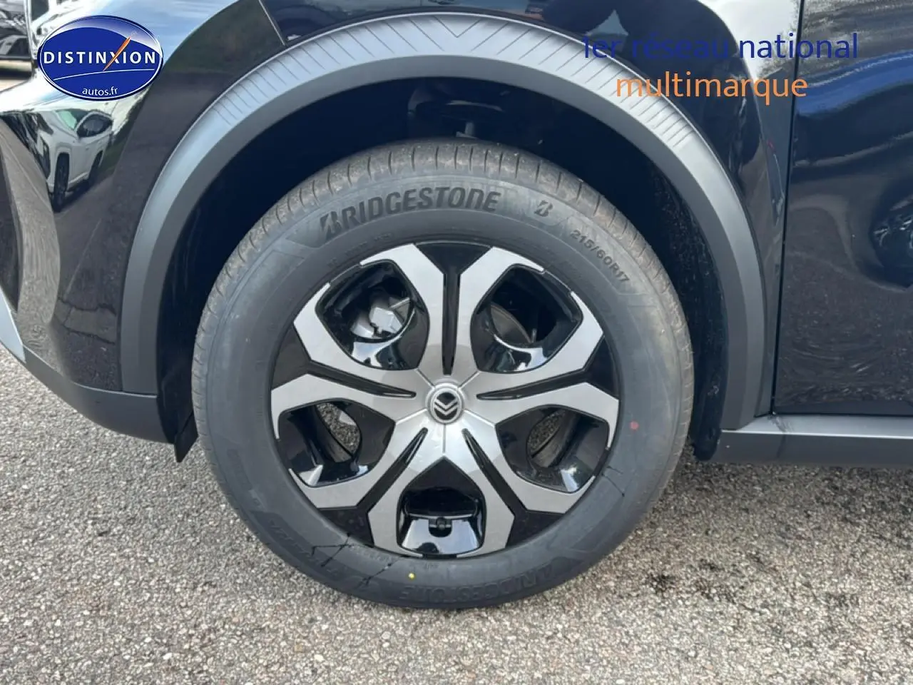 Gros plan sur la roue avant gauche noire du Citroën C3 Aircross 2025 avec jante alliage bicolore et pneu Bridgestone.