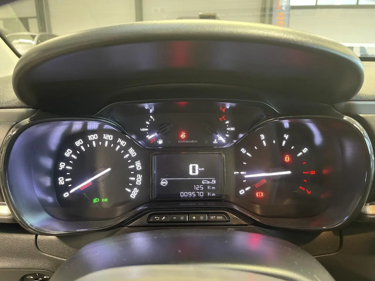 Vue rapprochée du tableau de bord numérique de la Citroën C3 beige clair 2024, affichant vitesse et compteurs.