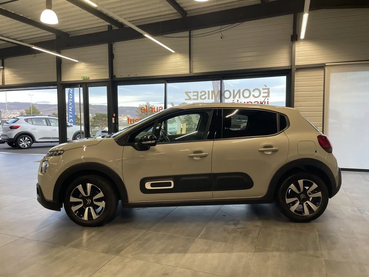 Citroën C3 beige clair vue de profil côté gauche, avec Airbump noir et jantes alliage diamantées.