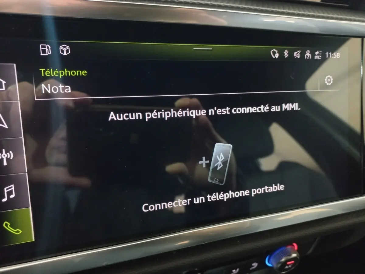 Écran tactile central de l'Audi Q3 blanc 2021 affichant la connexion Bluetooth pour téléphone portable.