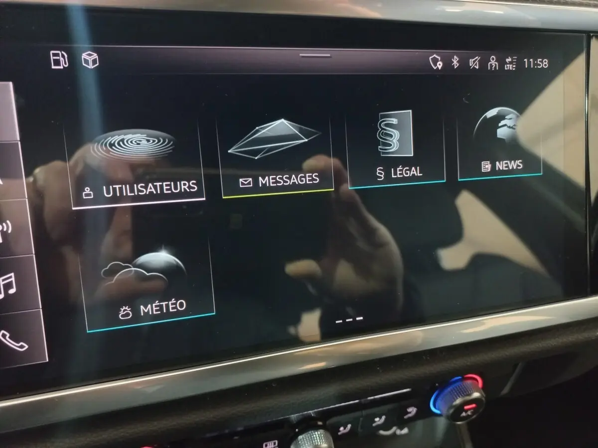 Écran tactile central de l'Audi Q3 blanc 45 TFSI E 2021 affichant les menus Utilisateurs, Messages, Légal, News et Météo.
