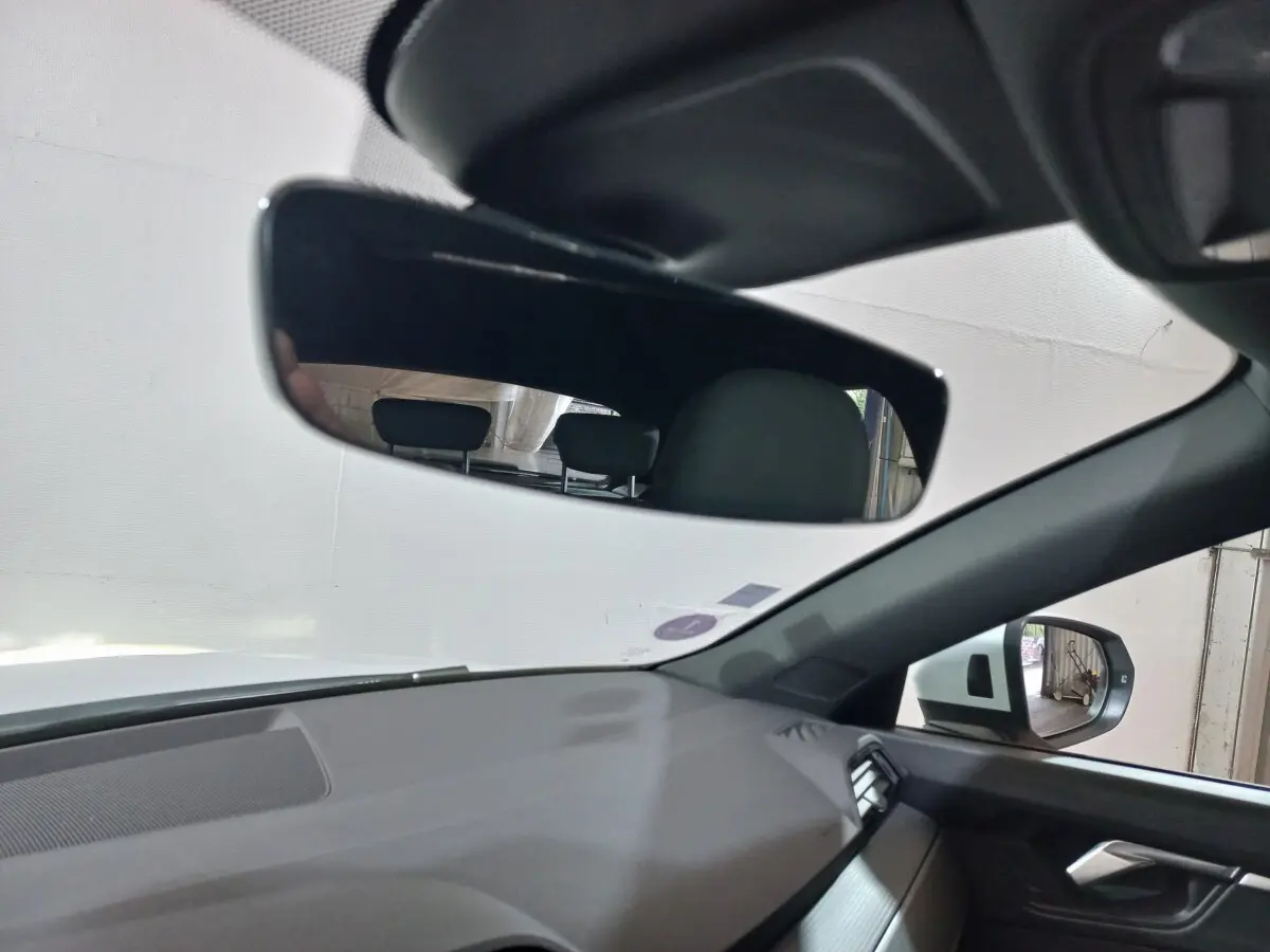 Vue intérieure de l'Audi Q3 45 TFSI e 2021, côté droit, montrant le rétroviseur intérieur et extérieur avec tableau de bord gris.