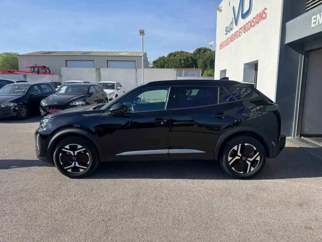 Peugeot 2008 Hybrid noir vue de profil côté gauche, avec jantes alliage 17 pouces et barres de toit visibles.