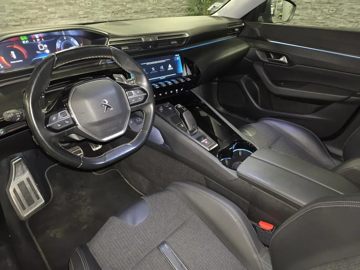 Vue intérieure côté conducteur de la Peugeot 508 SW noire, avec tableau de bord numérique et volant compact cuir.