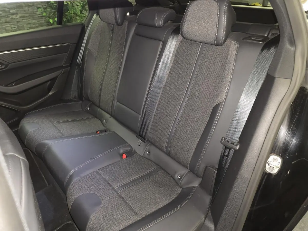 Vue intérieure côté droit des sièges arrière en tissu gris et cuir noir de la Peugeot 508 SW noire.