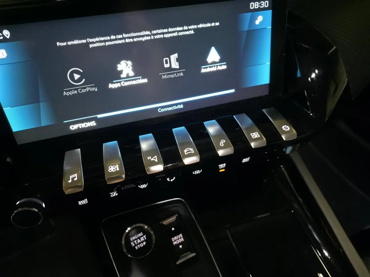Vue rapprochée de la console centrale noire du Peugeot 508 SW 2019 avec écran tactile et commandes piano chromées.