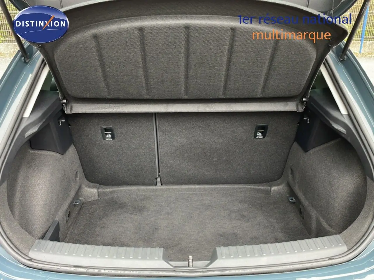 Coffre ouvert d’une SEAT LEON gris magnétique métal, vue arrière montrant l’espace de rangement vide et la doublure intérieure grise.