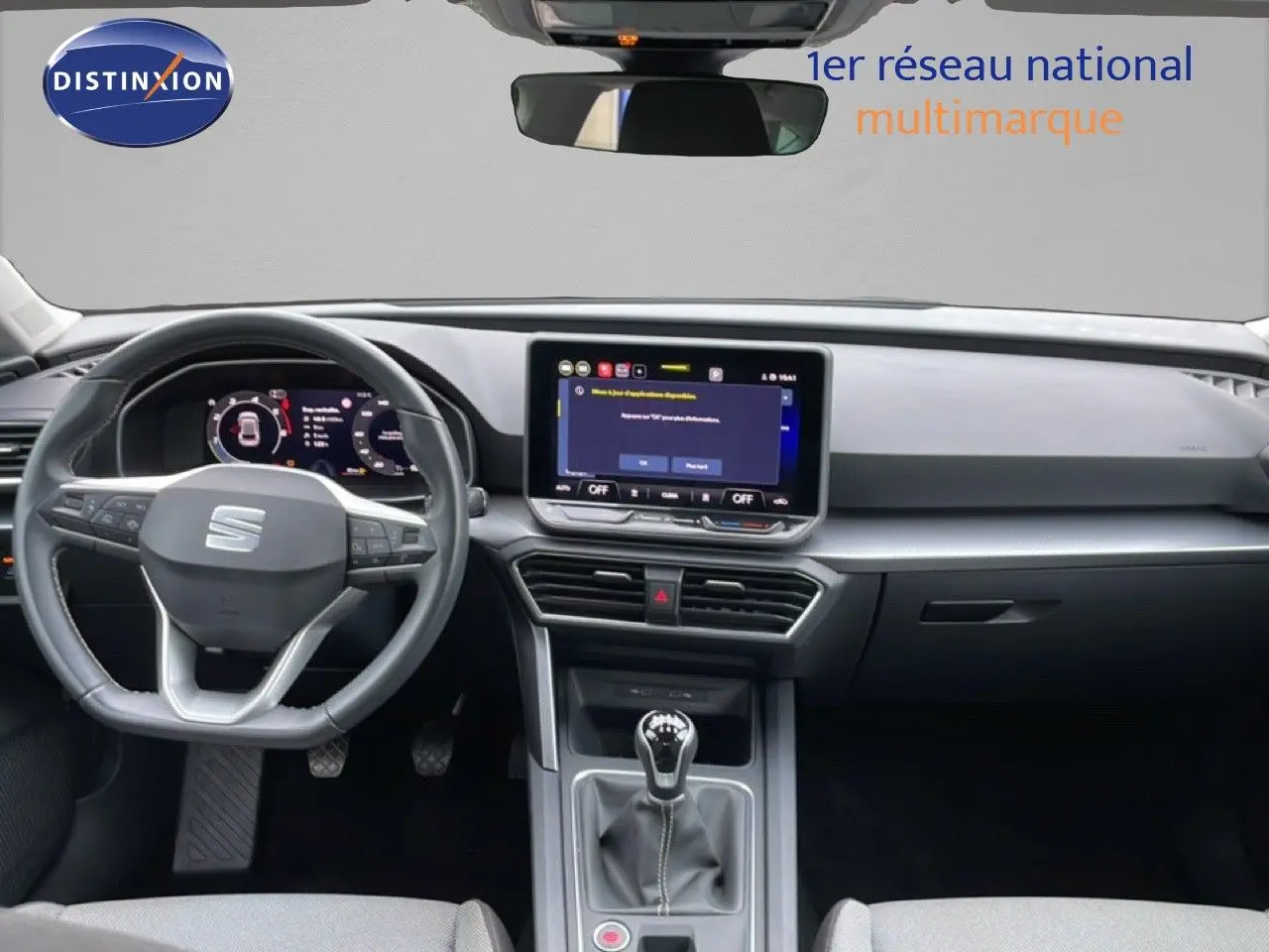 Vue intérieure avant du SEAT Leon 2025 gris métallique, avec volant multifonction, écran tactile et boîte manuelle.