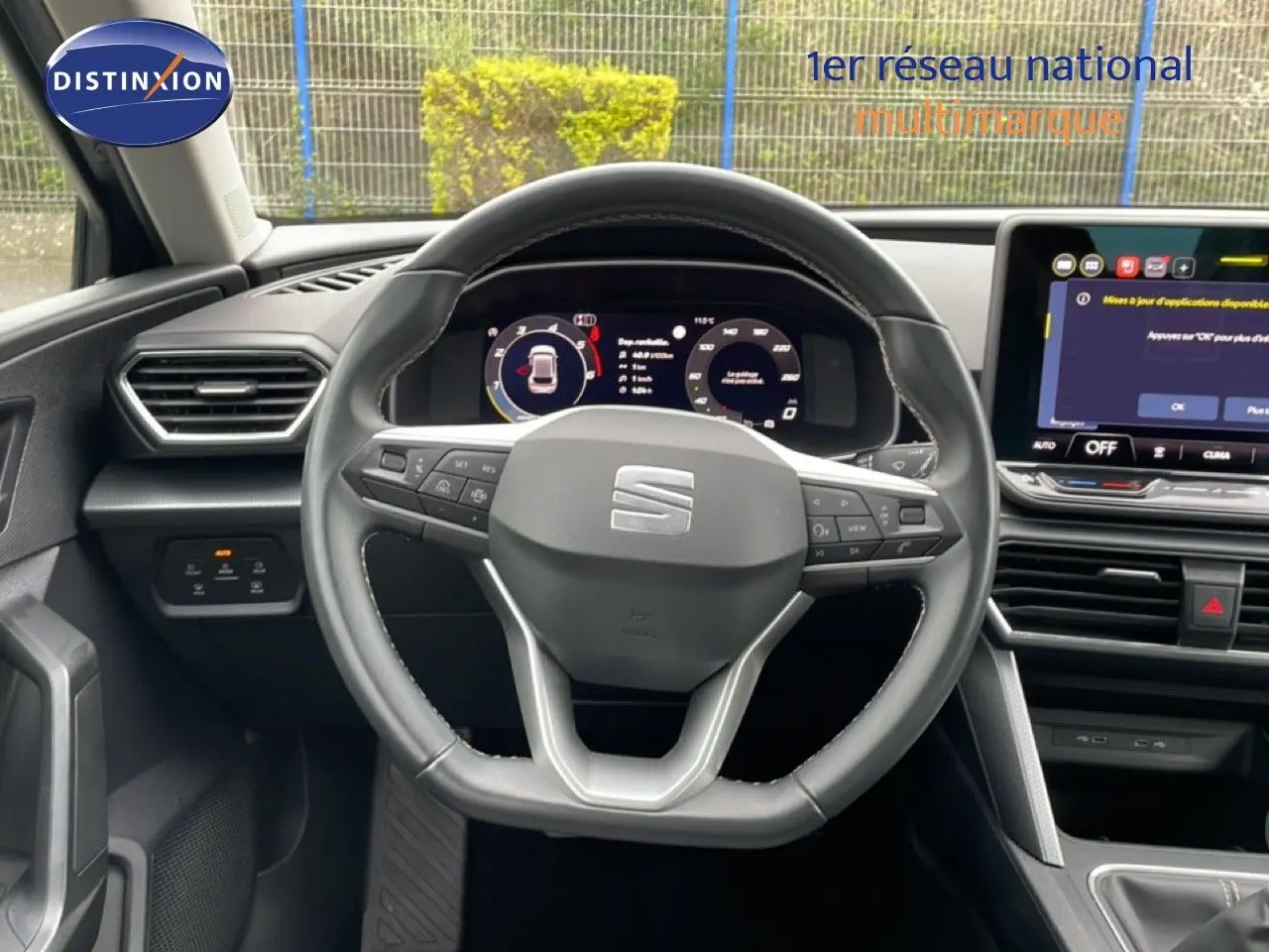 Vue intérieure centrée sur le volant cuir et le tableau de bord numérique du SEAT LEON gris métallique 2025.