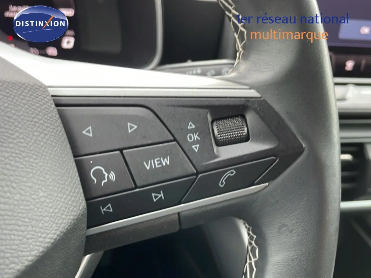 Gros plan sur les commandes multifonctions en cuir noir du volant du SEAT LEON 2.0 TDI gris magnétique 2025.