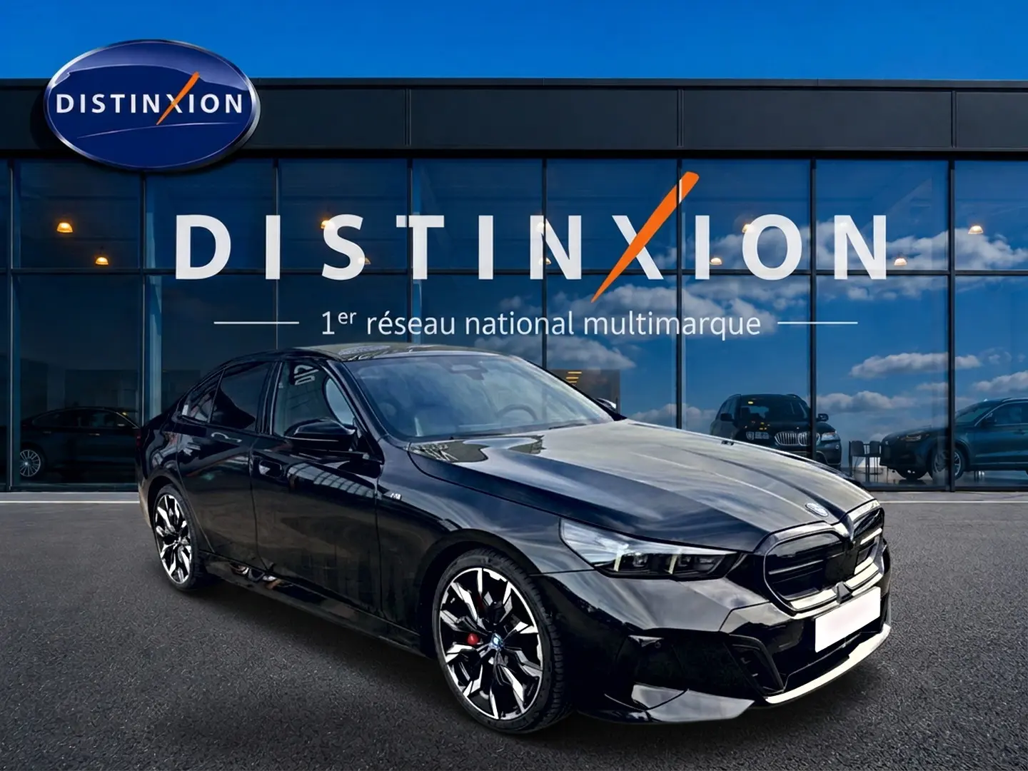 BMW Série 5 i5 M60 noir vue 3/4 avant droit, avec jantes alu bicolores et calandre noire distinctive.