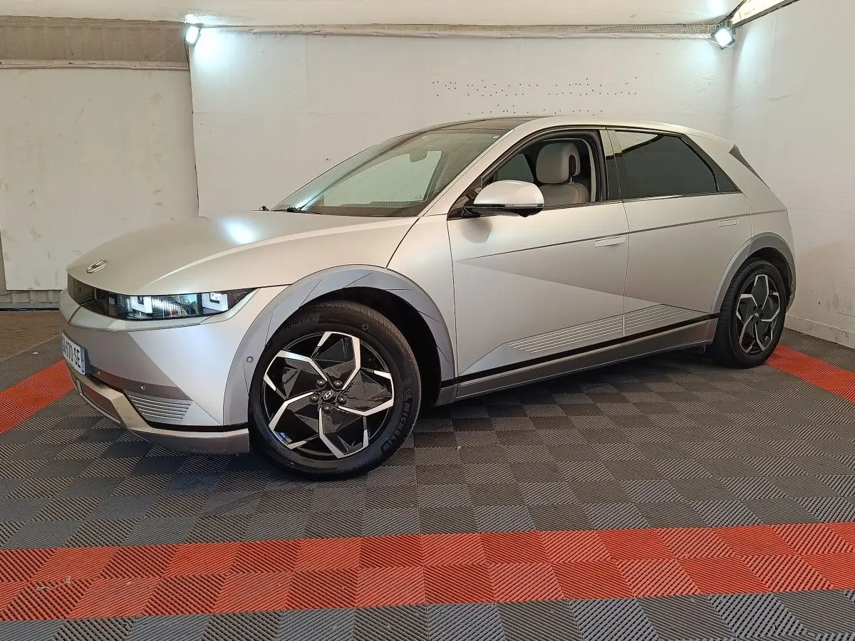 Hyundai IONIQ électrique beige vue 3/4 avant droit dans un garage avec jantes noires et grises distinctives.