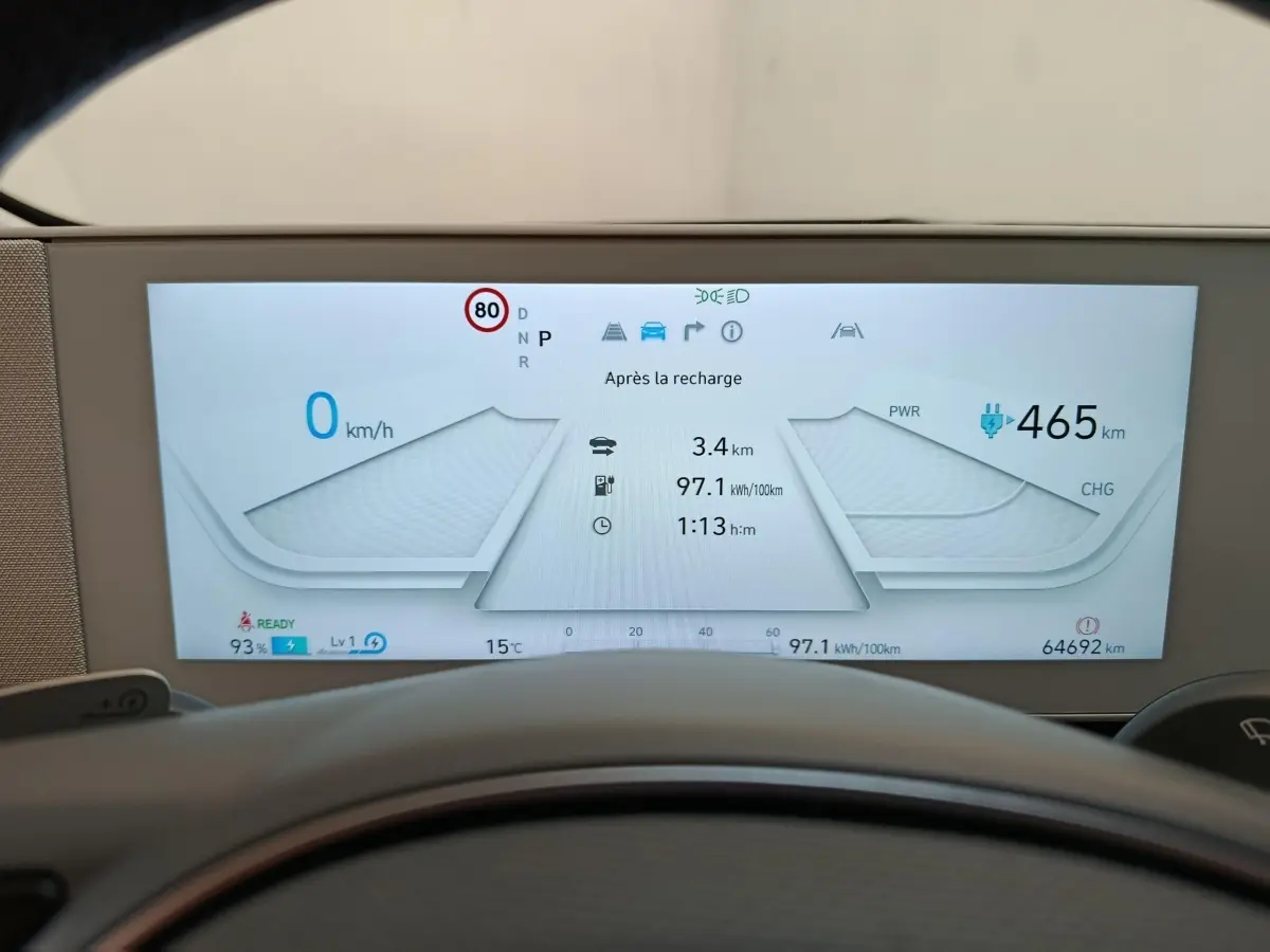 Tableau de bord numérique de Hyundai IONIQ BEV 77KWH AWD beige, affichage vitesse et autonomie électrique.