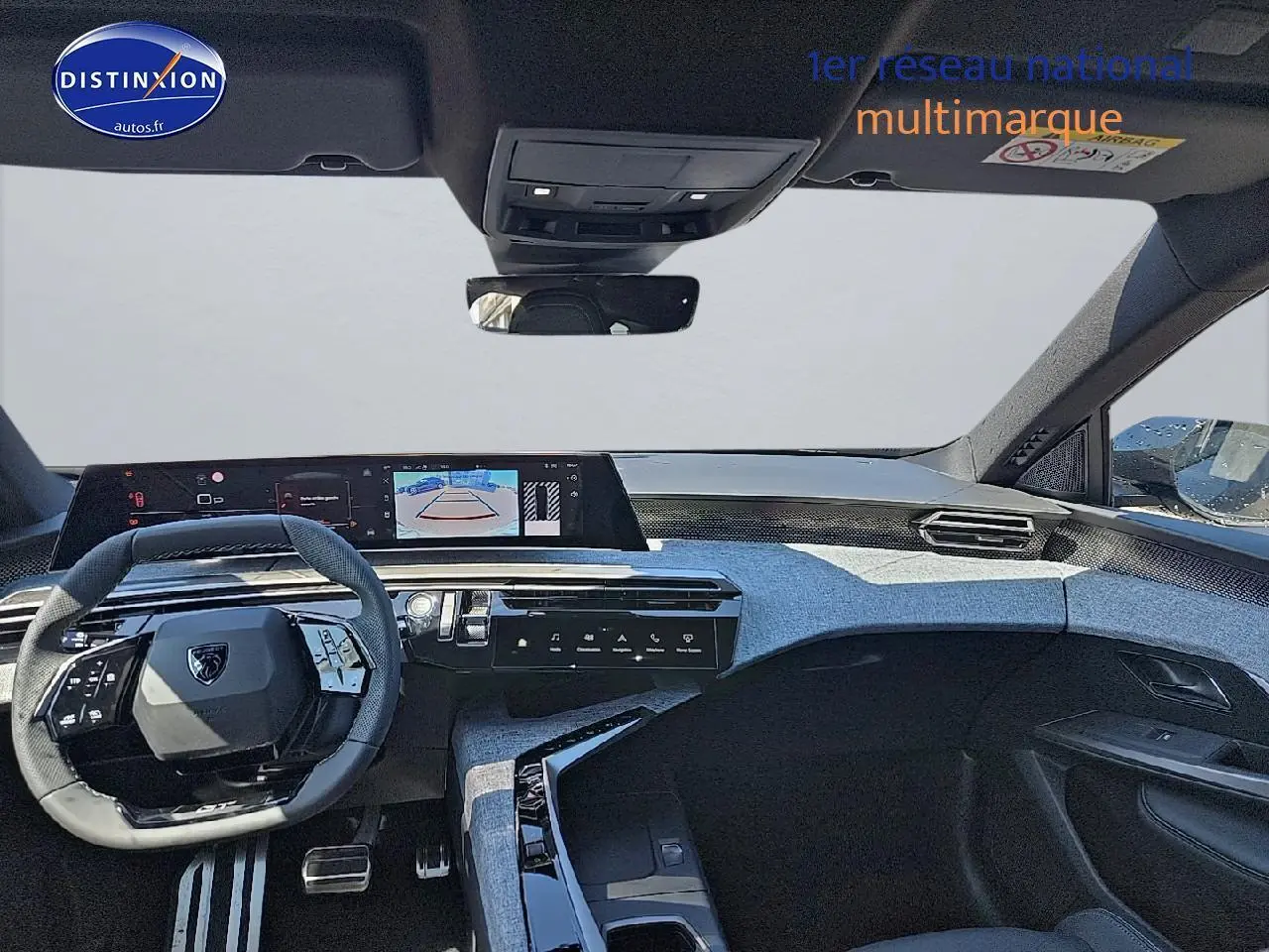 Vue intérieure frontale du tableau de bord et volant cuir noir du Peugeot 5008 Hybrid 145 GT gris titane 2025.