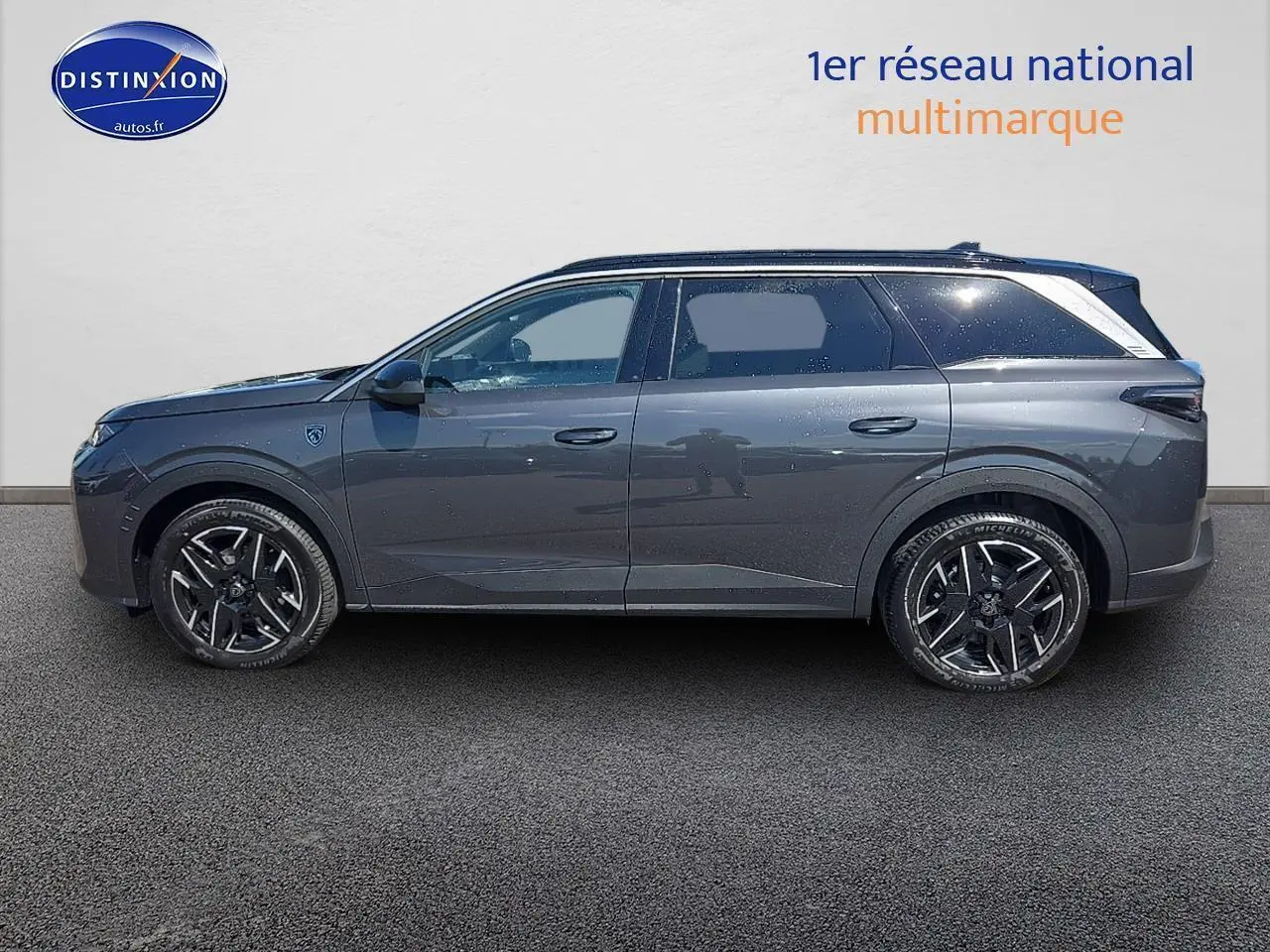 Profil latéral droit du Peugeot 5008 Hybrid 145 GT e-dcs6 gris titane avec jantes alu noires brillantes.