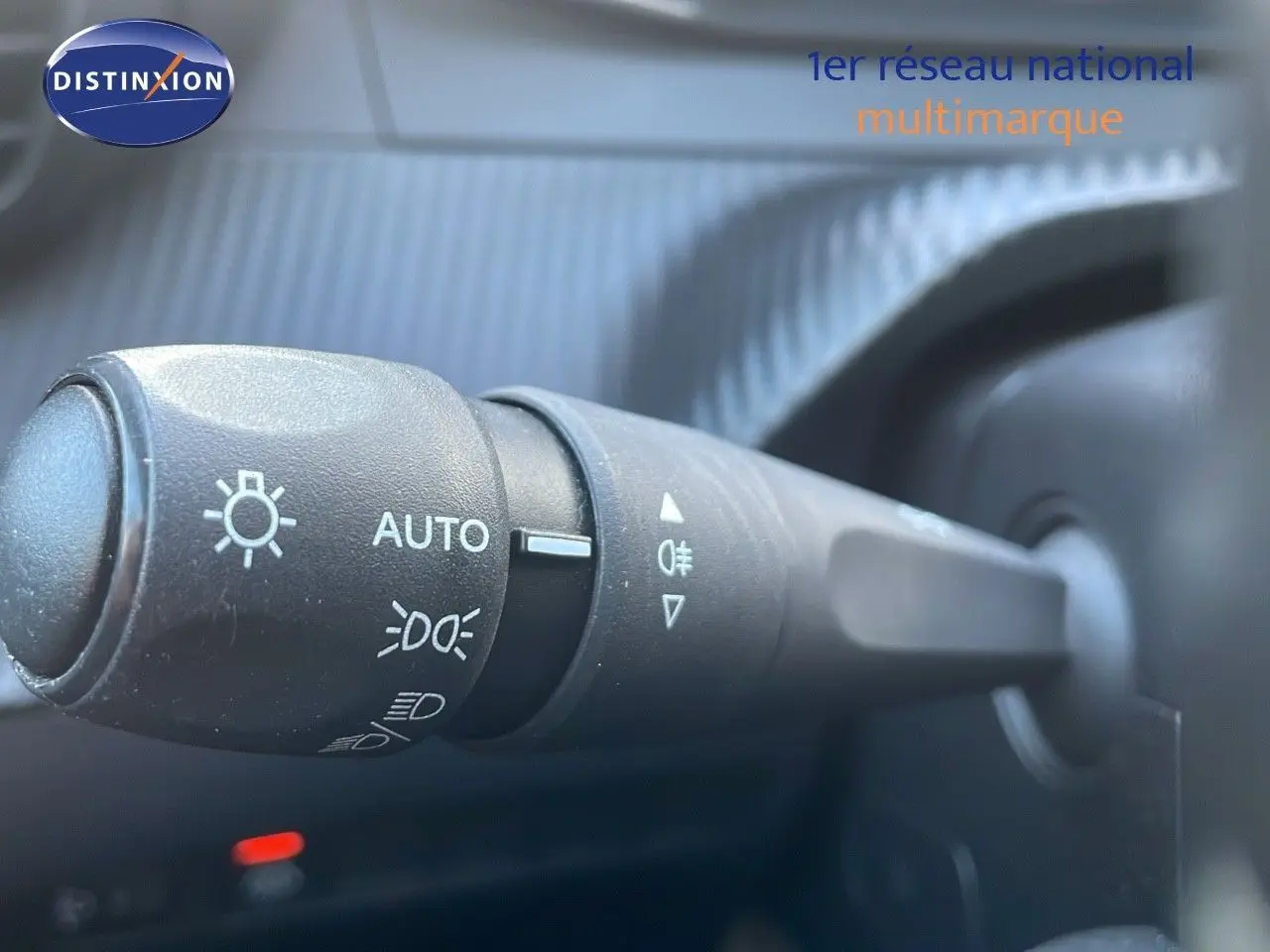 Gros plan sur la commande des phares d'une Peugeot 208 électrique gris Artense, intérieur côté gauche.