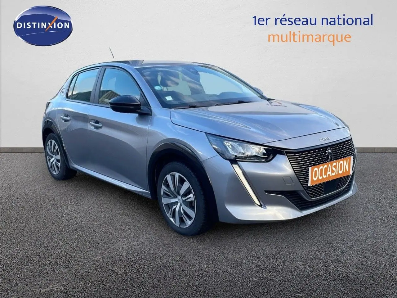 Peugeot 208 électrique gris Artense vue 3/4 avant gauche avec calandre distinctive et feux LED diurnes en forme de griffes.