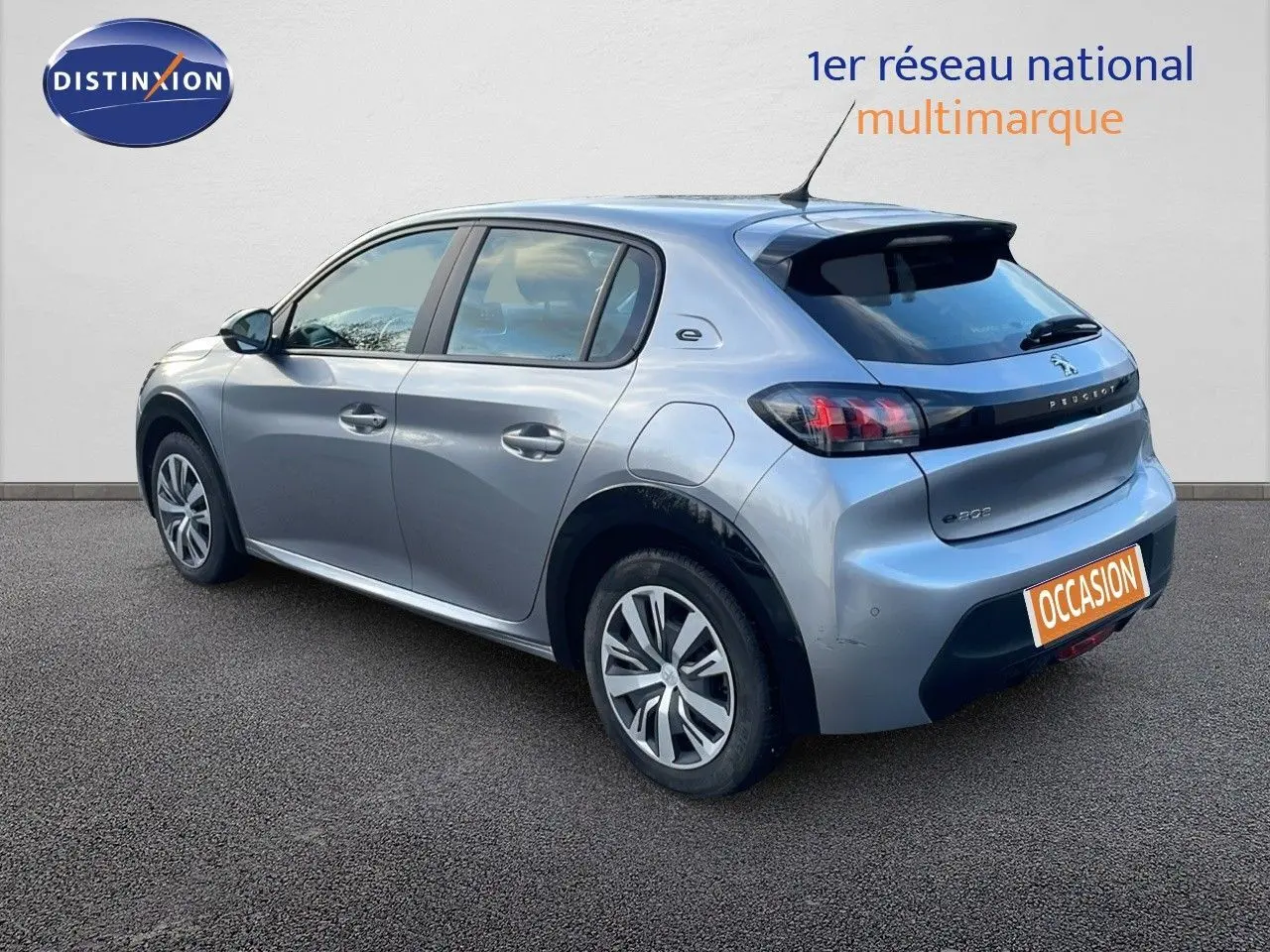 Peugeot 208 électrique gris Artense vue 3/4 arrière côté gauche avec jantes et logo e-208 visibles.