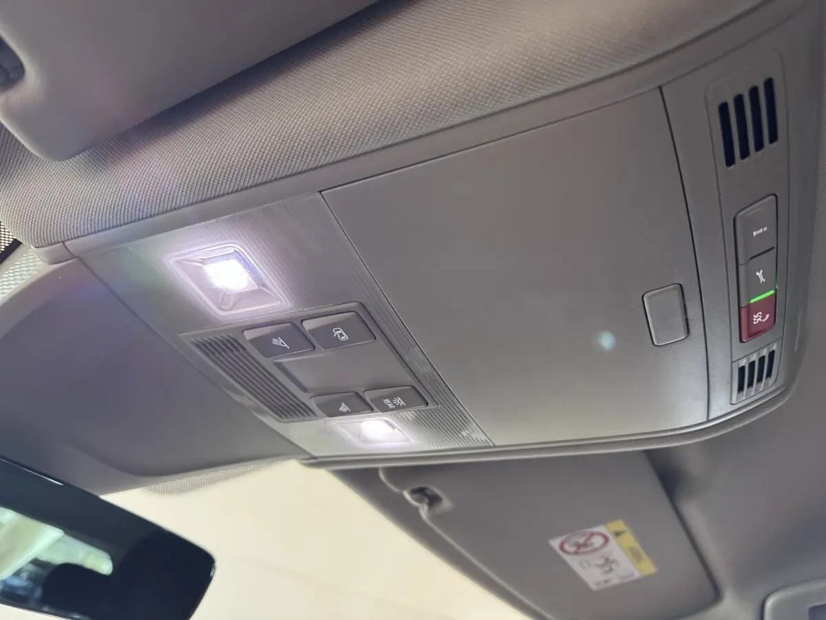 Vue intérieure du plafond avant du Volkswagen Tiguan bleu 2021, avec éclairage et commandes intégrées.