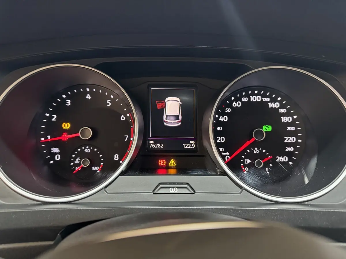 Vue rapprochée du tableau de bord du Volkswagen Tiguan 2021, affichant les compteurs et l'alerte porte ouverte.