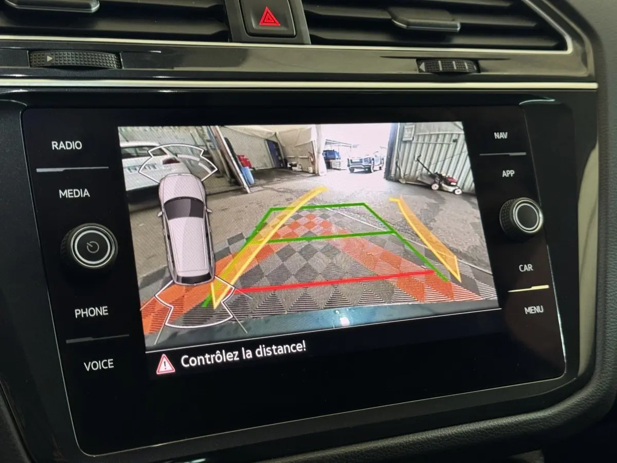 Écran tactile central du Volkswagen Tiguan 2021 affichant la caméra de recul avec lignes de guidage colorées.