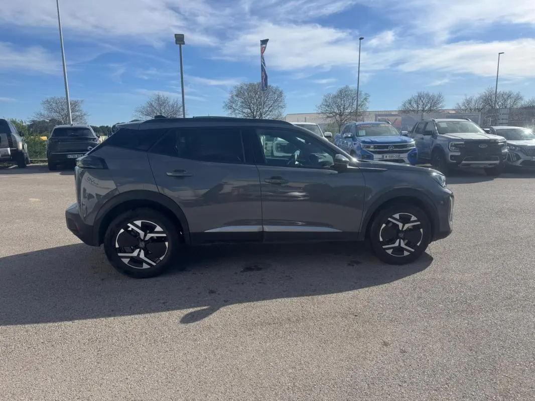 Peugeot 2008 Hybrid gris en profil droit, avec jantes alliage 17 pouces et toit noir contrasté.