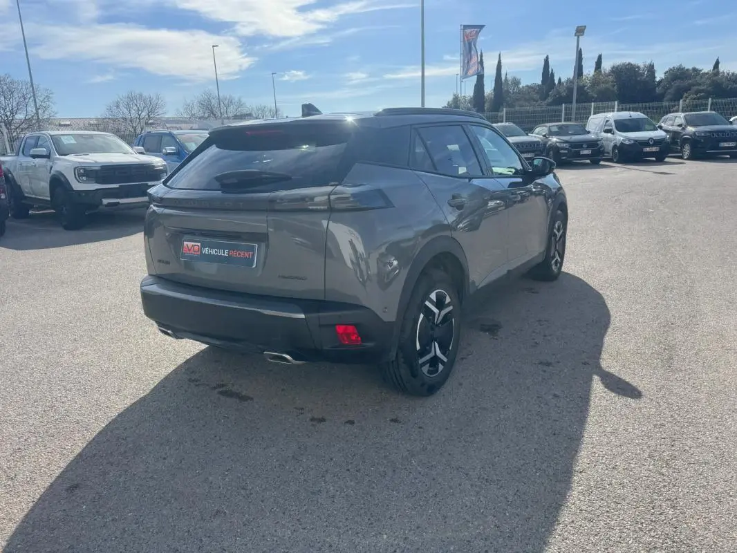 Peugeot 2008 Hybrid 145 gris en 3/4 arrière droit, jantes alliage 17 pouces et feux arrière LED distinctifs.