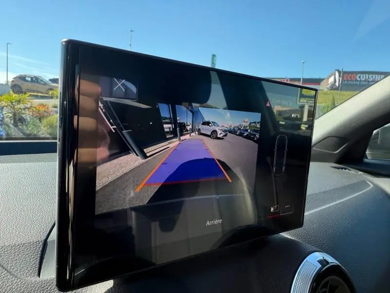 Écran intérieur montrant la caméra de recul d'un Audi Q2 35 TDI S line gris Daytona nacré en vue arrière.