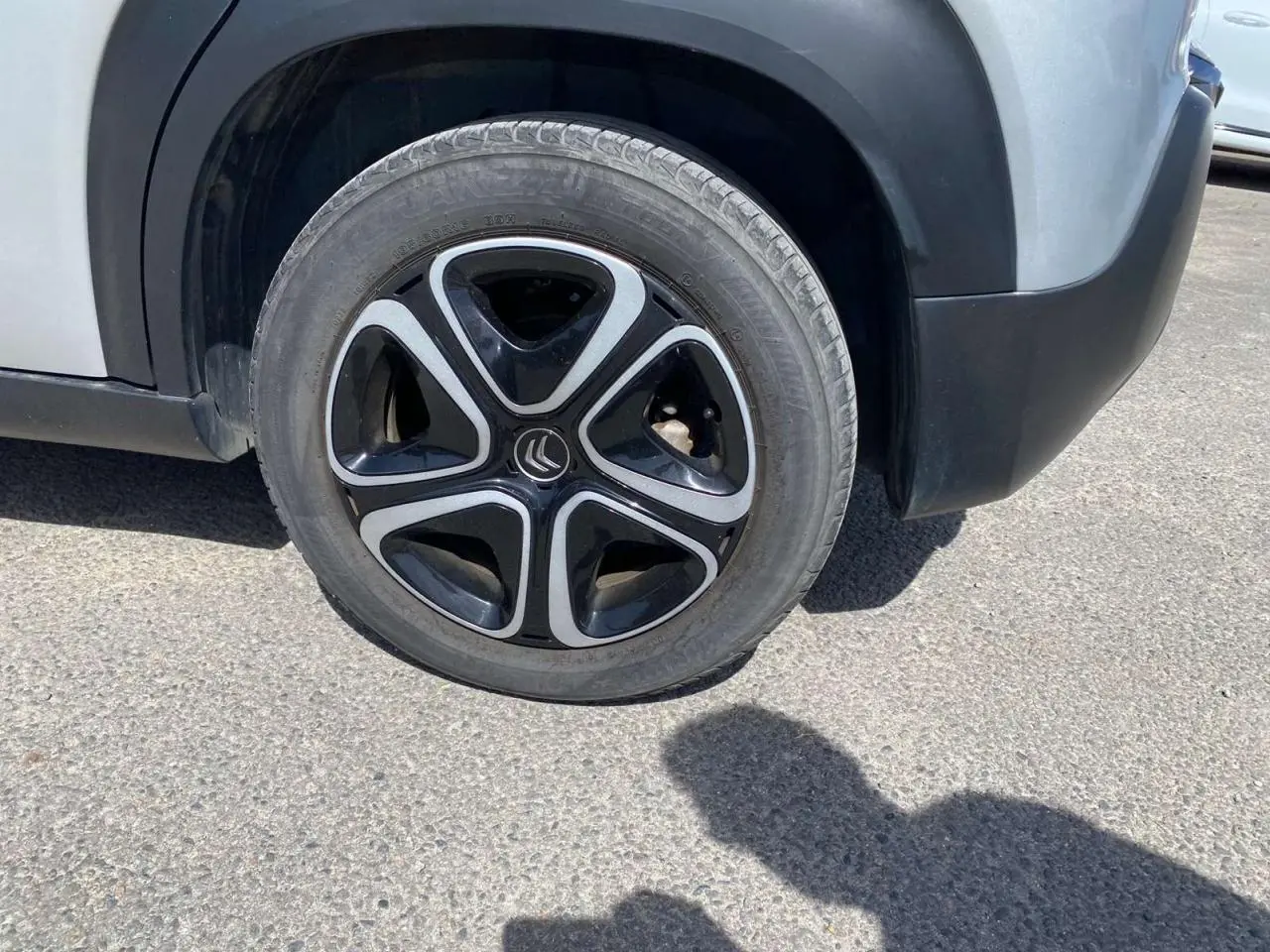 Gros plan sur la roue avant droite d'un Citroën C3 Aircross gris Artense avec protections noires autour des passages de roue.