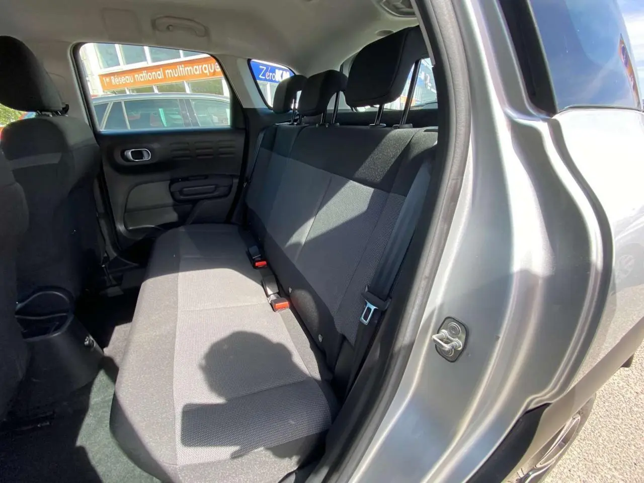 Vue intérieure sur la banquette arrière côté droit du Citroën C3 Aircross gris Artense avec porte ouverte.