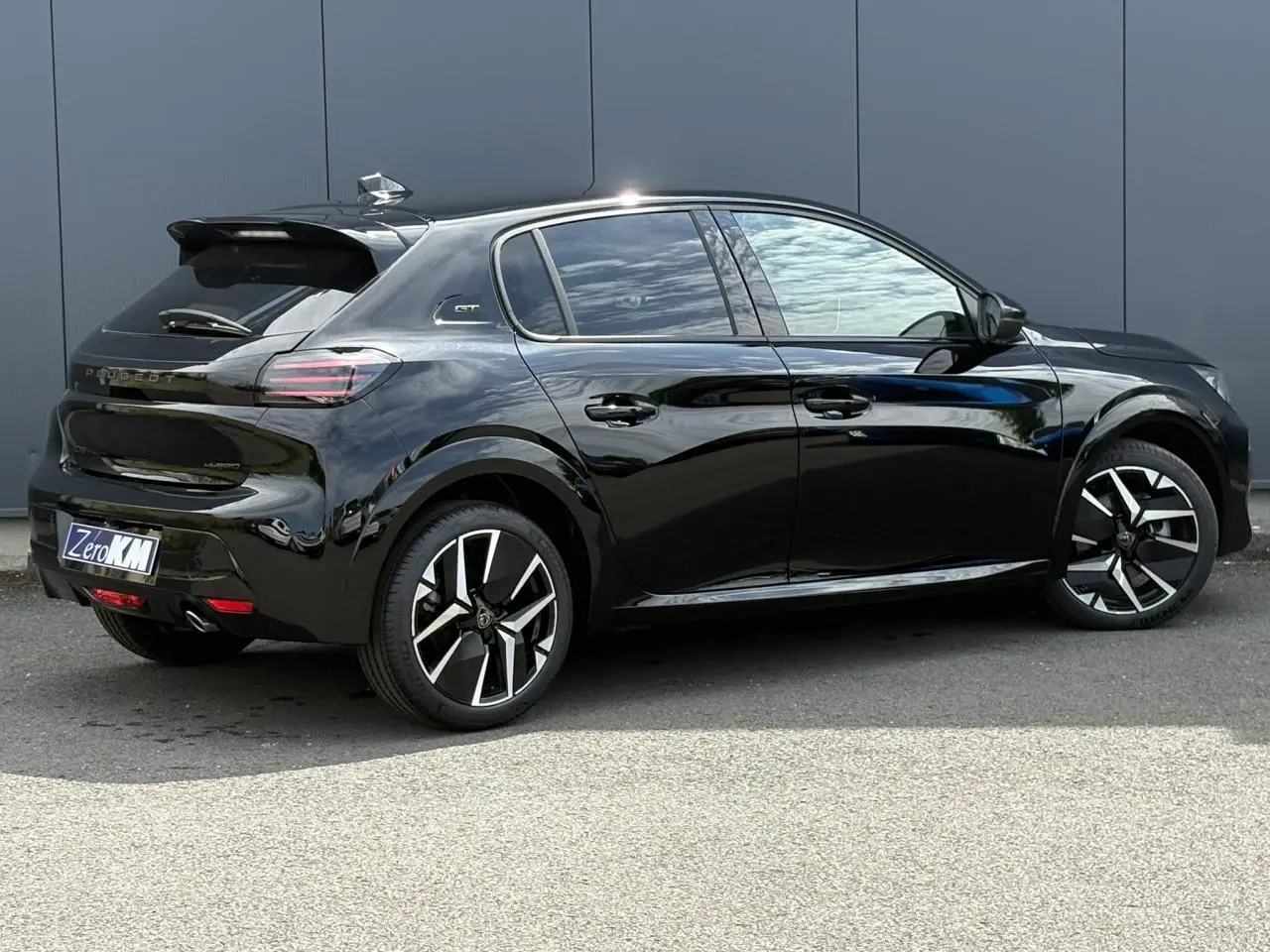 Peugeot 208 Hybrid 110 GT noir Perla vue de profil droit avec jantes alliage bi-ton et toit noir.