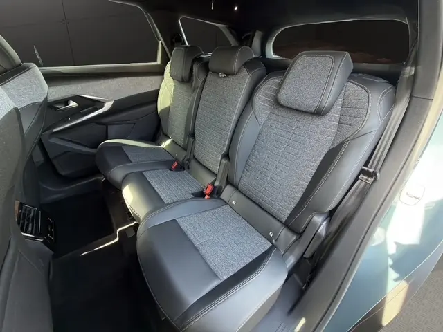 Vue intérieure côté droit sur la deuxième rangée de sièges individuels en tissu gris et cuir noir du Peugeot 5008 bleu 2025.