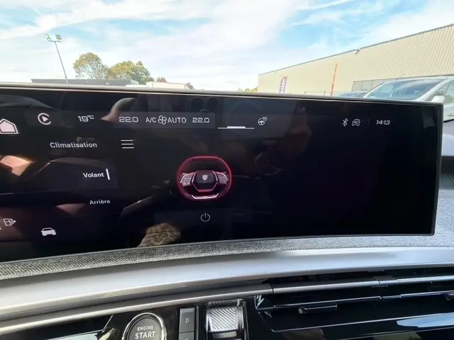 Écran tactile multifonctions de 10 pouces du tableau de bord du Peugeot 5008 bleu, affichant les réglages climatisation et volant.