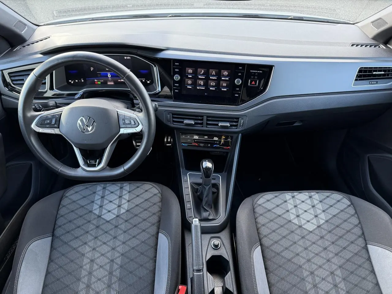 Intérieur du Volkswagen Polo 2025 vu de face, volant cuir multifonction et écran tactile central noir.