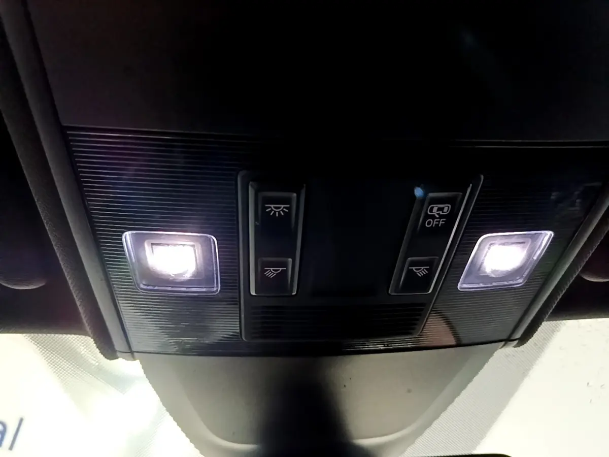 Vue intérieure en gros plan du plafonnier avec éclairage et commandes dans un Volkswagen Taigo blanc 2022.