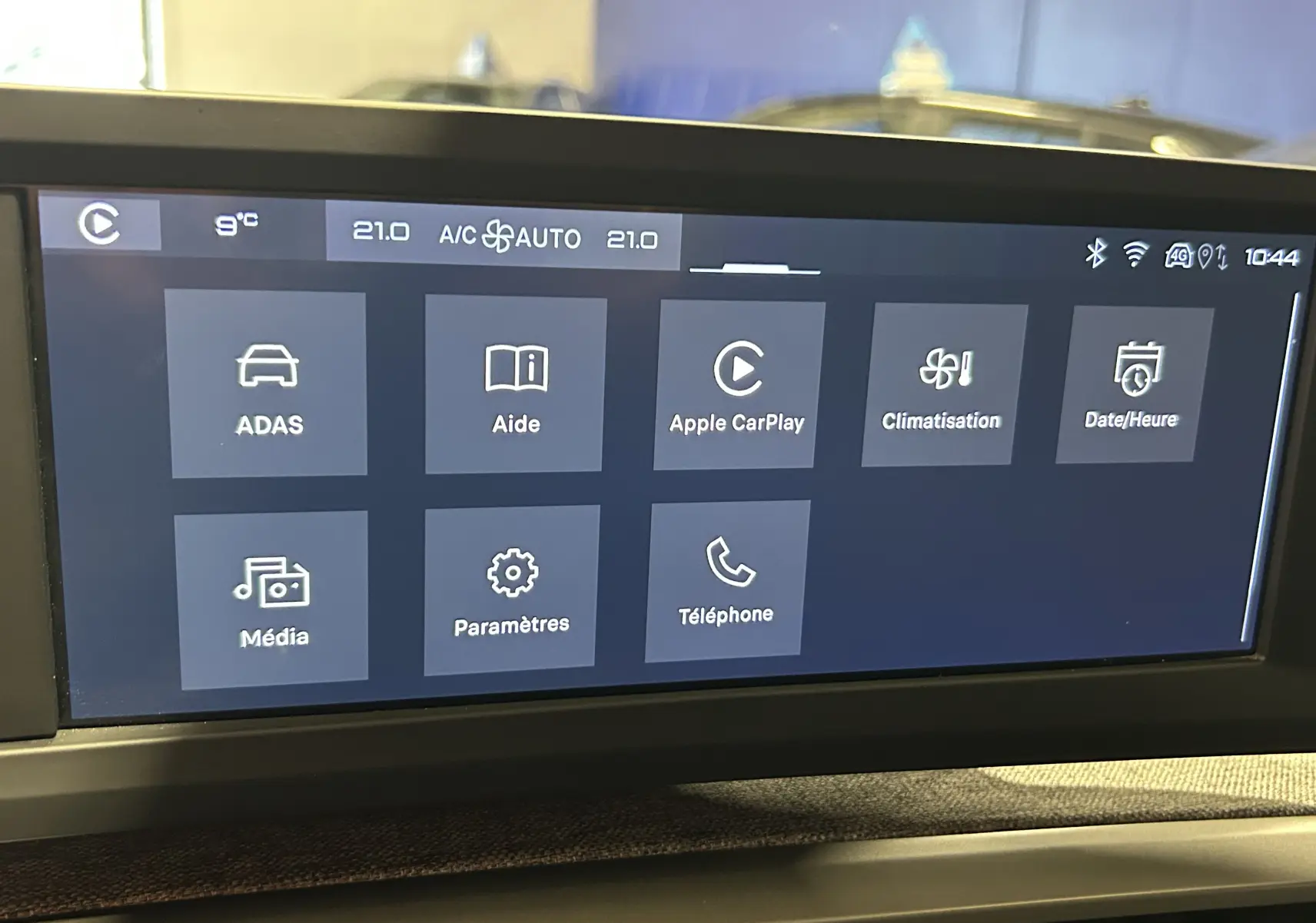 Écran tactile central du Peugeot 5008 III Hybrid 145 en mode menu avec options Apple CarPlay et climatisation visible.