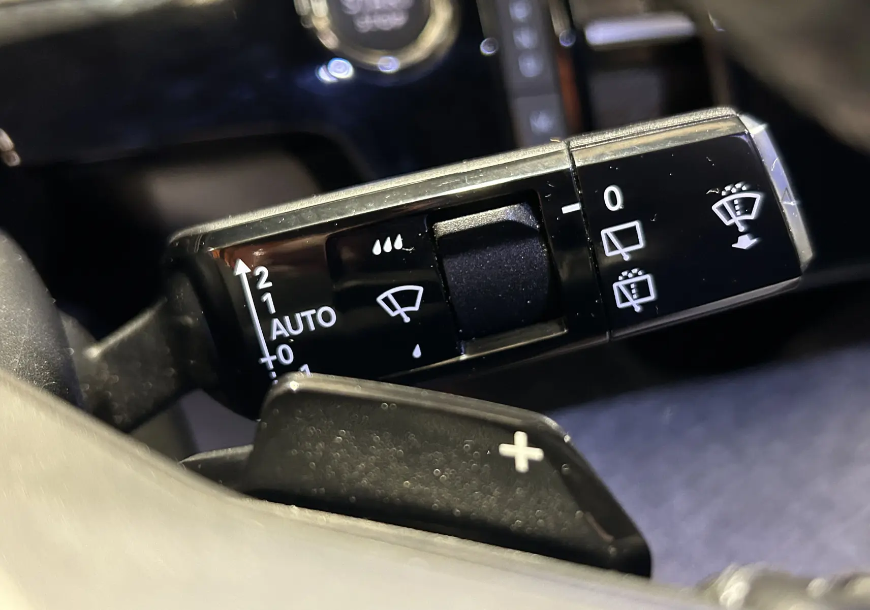 Gros plan sur la commande de l’essuie-glace et la palette de changement de vitesse dans l’habitacle du Peugeot 5008 gris Artense.