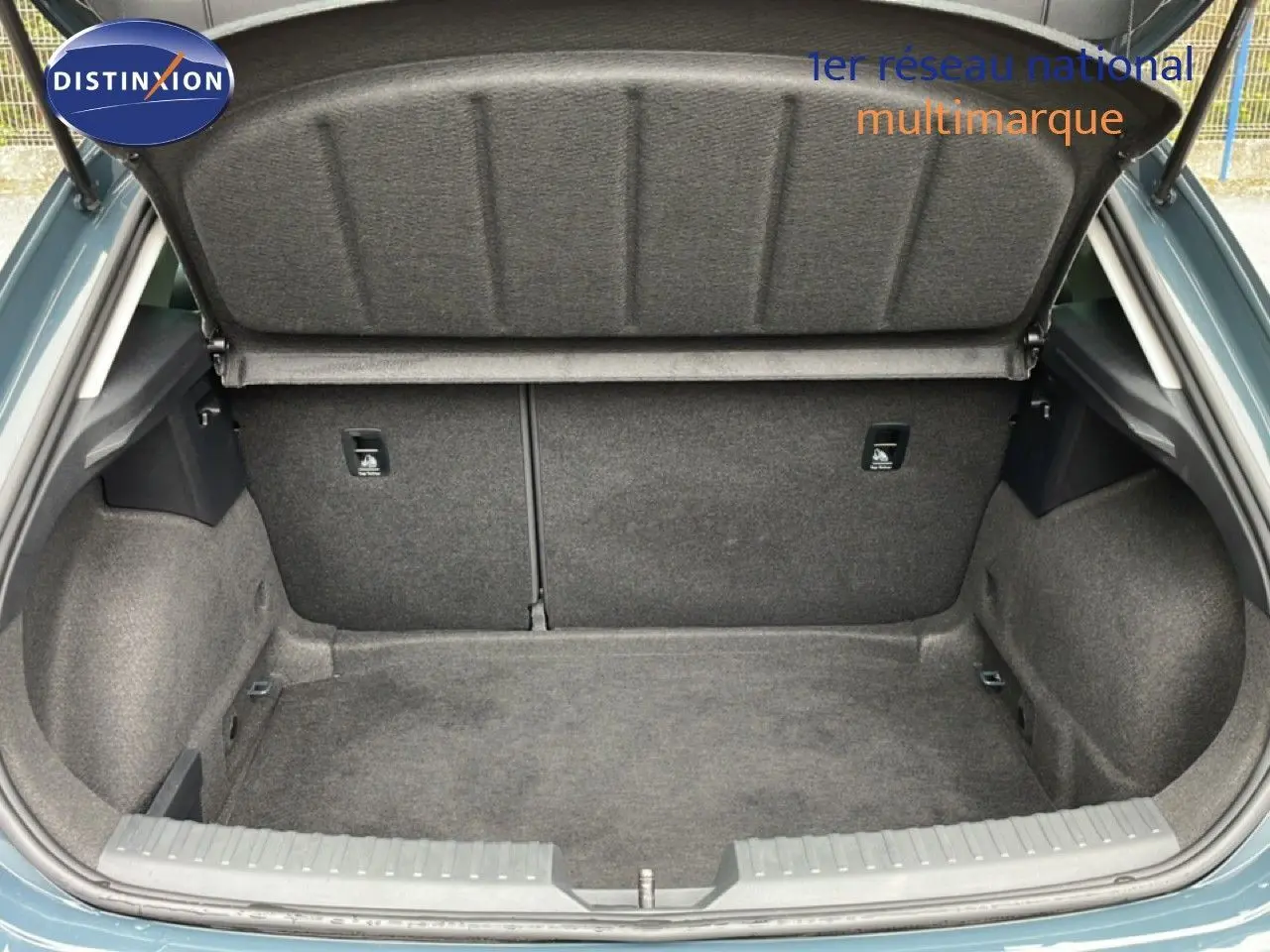 Coffre ouvert vu de l'arrière d'une SEAT LEON 2.0 TDI bleu Fjord, montrant un espace de chargement propre et spacieux.