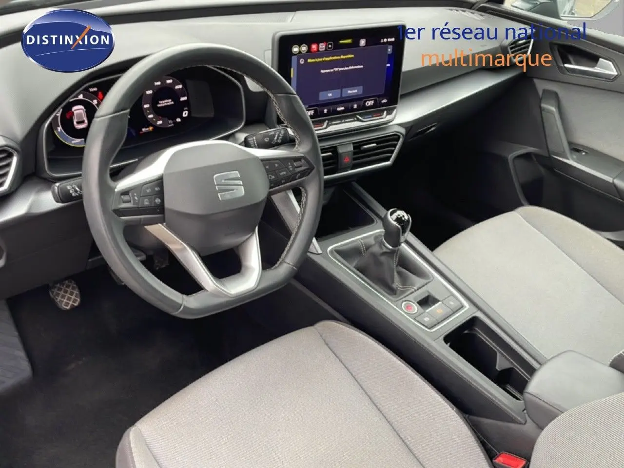 Vue intérieure côté conducteur de la SEAT LEON 2025, tableau de bord numérique et console centrale avec boîte manuelle.