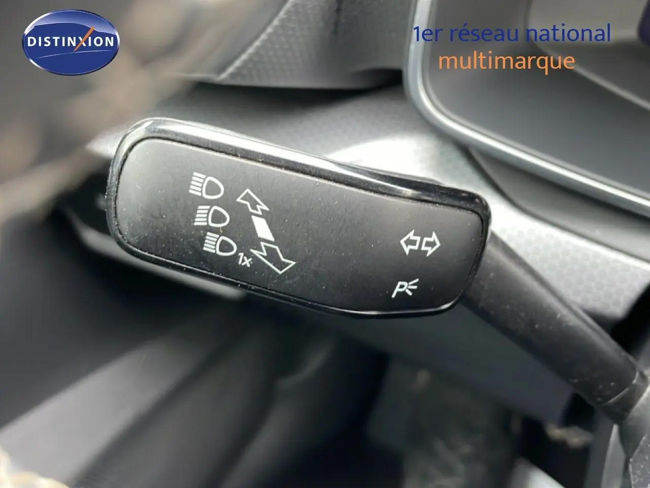 Gros plan sur le commodo de clignotants et feux d’un SEAT Leon 2025, intérieur gris noir.